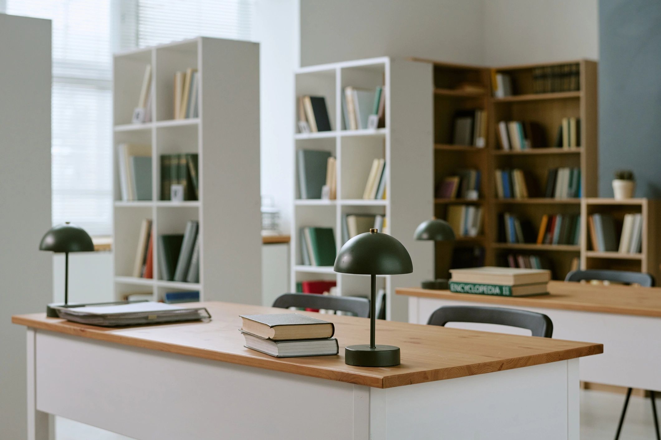 Wide library interior with books, desks, and warm reading atmosphere